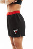 Woman wearing black and red Fighters Choice Everlasting Fight Shorts, with the Fighters Choice logo on the left leg pant, the apparel elite fighters use to look sharp on the BJJ mat