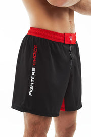 Right View of man wearing black and red Fighters Choice Everlasting Fight Shorts, with the Fighters Choice name on the right leg pant, the best shorts to look sharp on the BJJ mat